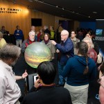 Guests gather around the iGlobe and talk with MIT scientists about atmospheric circulation. Credit: John Gillooly