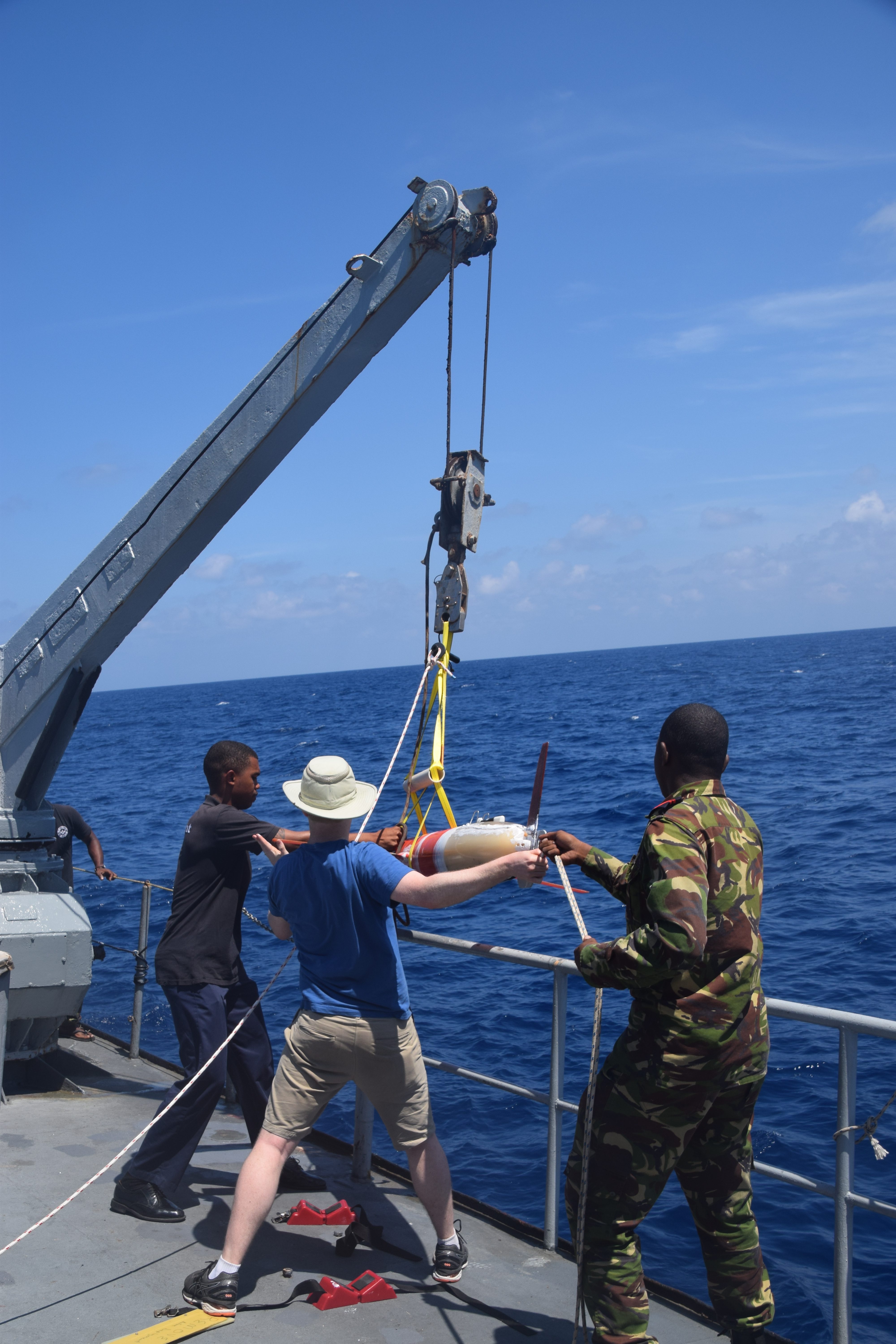 Robert and two crew members using the crane on the Étoile to lift the glider into the water. (Photo: Joleen Heiderich, MIT/WHOI Joint Program)